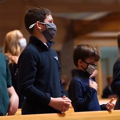 Students pray at a school Mass.